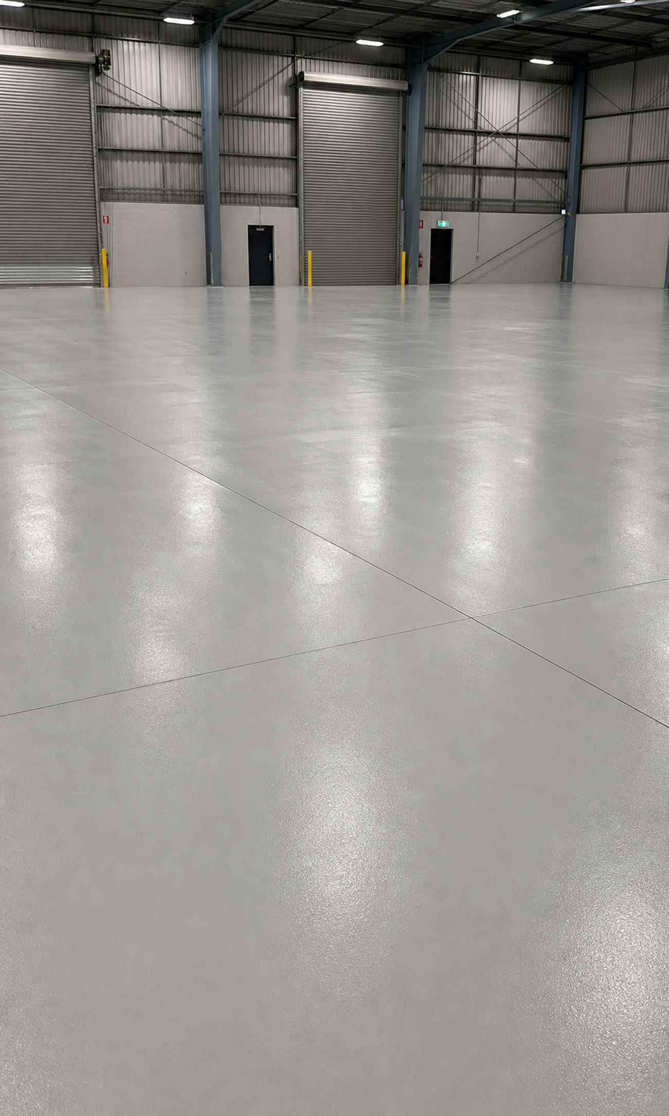 Finished light grey epoxy floor inside an industrial warehouse