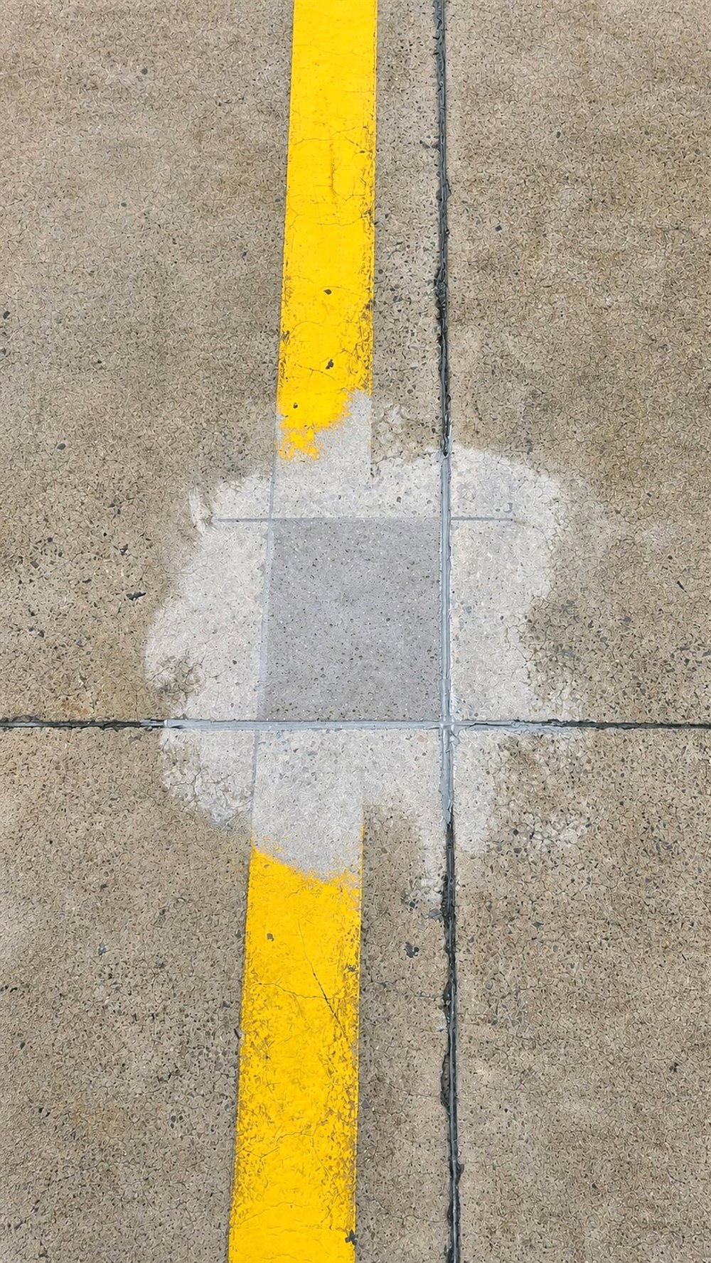 Concrete joint repair beside warehouse line marking